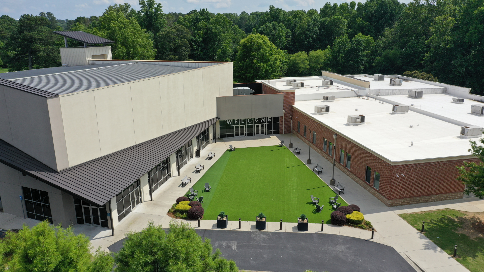 Aerial of a building complex with central courtyard, lawn, and seating