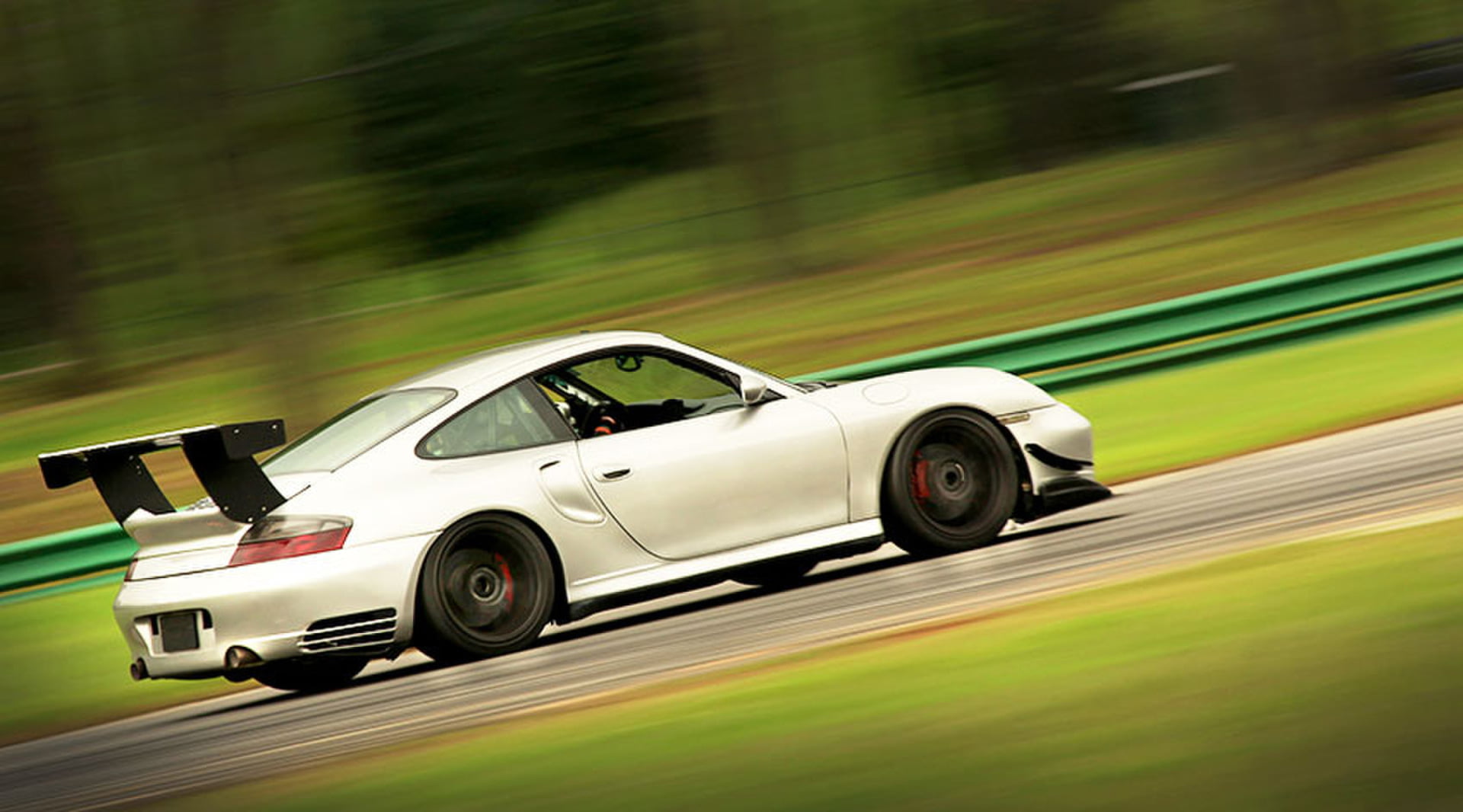 White Porsche 911 GT3 panning shot through the trees