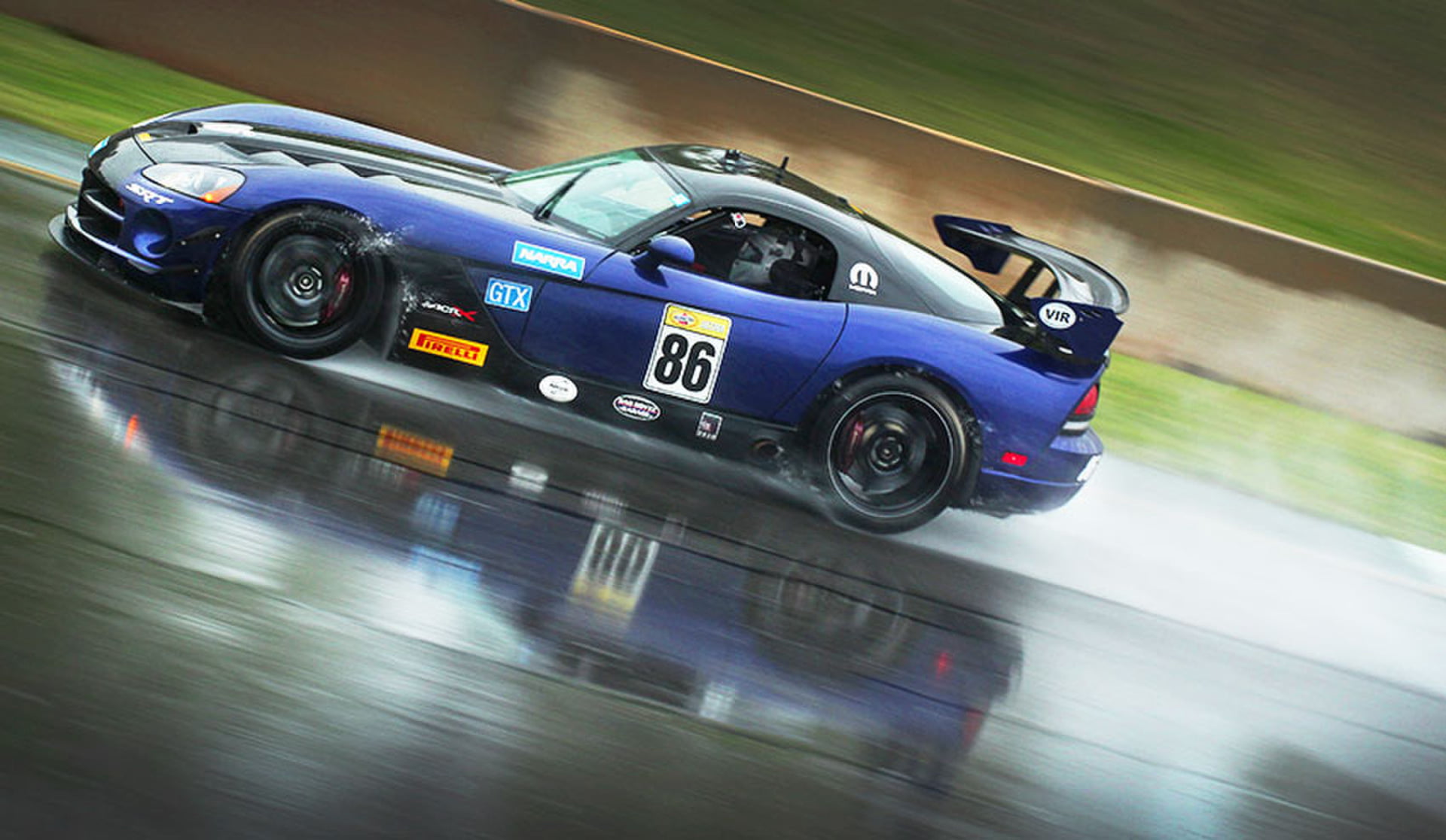 Blue Viper #86 cutting through standing water on a wet circuit
